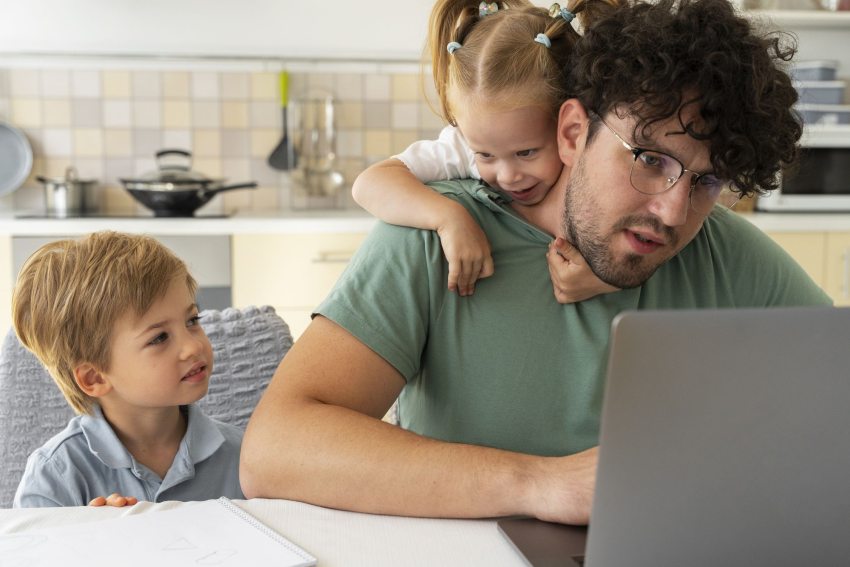 munkaalkoholizmus miatt gyerekei mellett is laptopját néző férfi